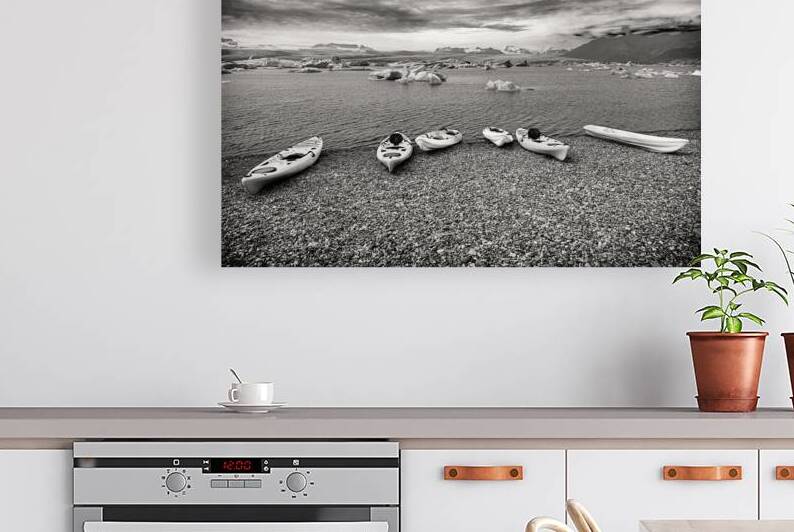 Colorful kayaks resting on a rocky beach awaiting kayakers in ic by Gualtiero Boffi