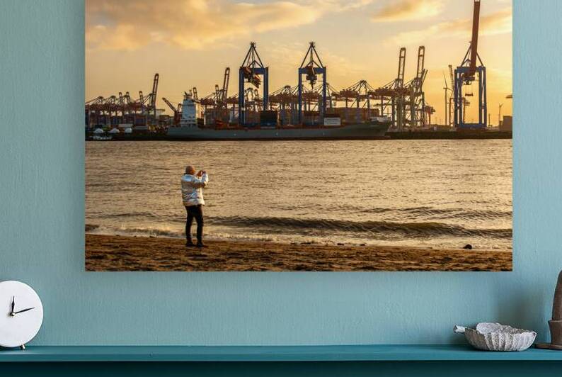 Man taking pictures at the Elbe River in Hamburg in front of harbor district at sunset by caladoart