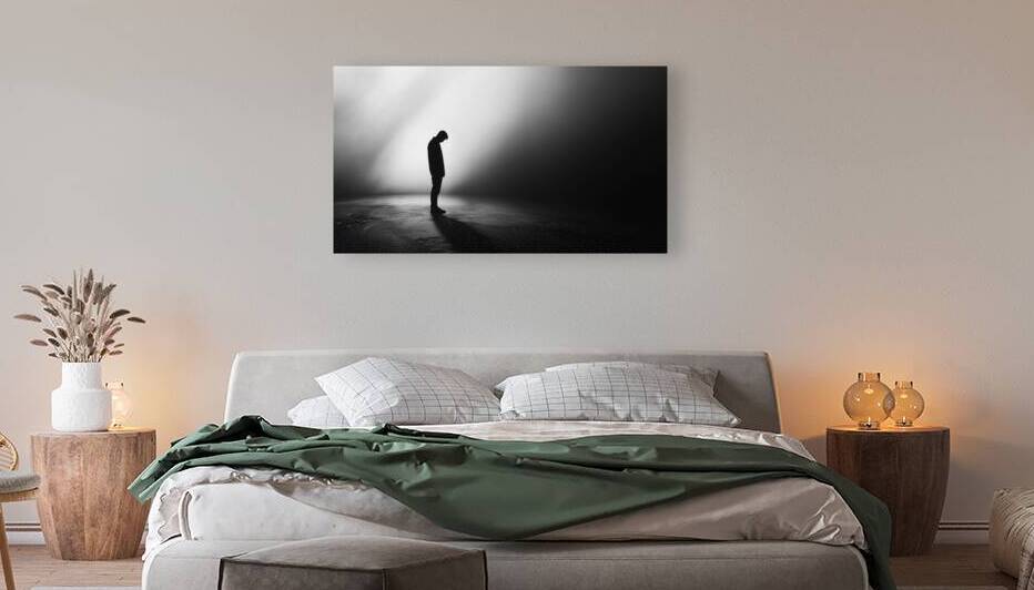 Silhouette of a person standing in solitude against a dark backdrop with dramatic lighting effects by Ali Jaber