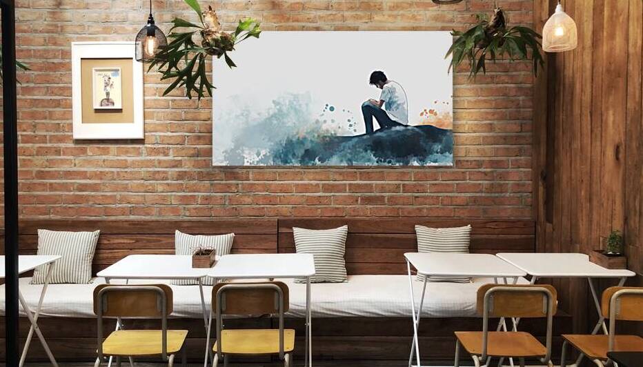 Young man seated thoughtfully by ocean waves reflecting on life during serene sunset hour by Ali Jaber