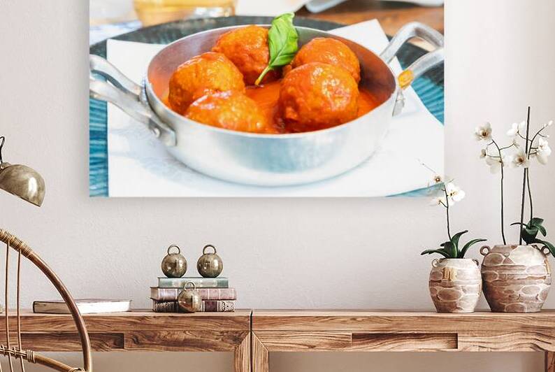 Traditional meatballs served with a basil leaf and tomato sauce. by Paolo Modena