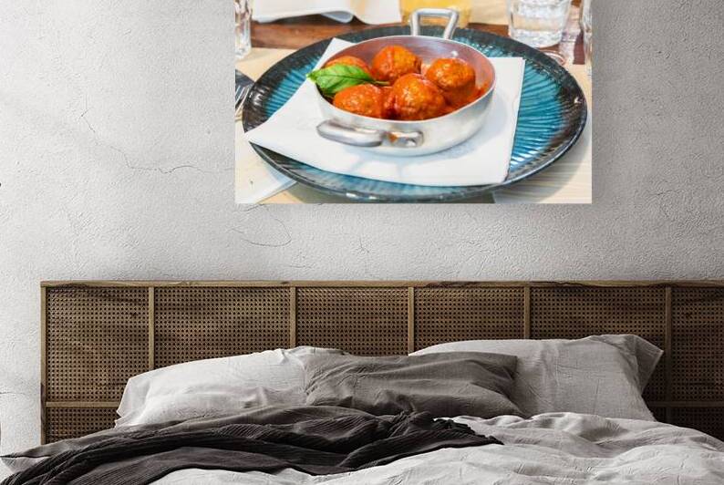 Traditional meatballs served with a basil leaf and tomato sauce. by Paolo Modena