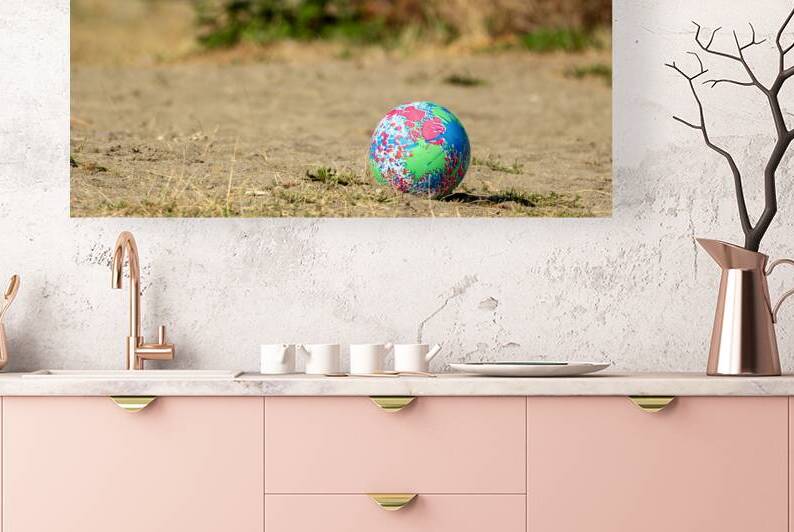 Lost play ball lying on beach by Lisa von Biela