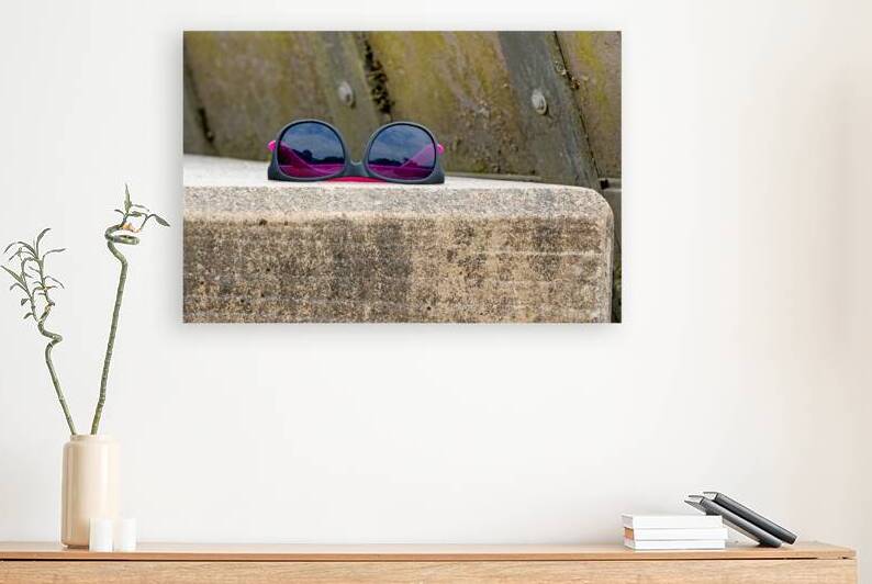 Abandoned sunglasses on concrete ledge by Lisa von Biela