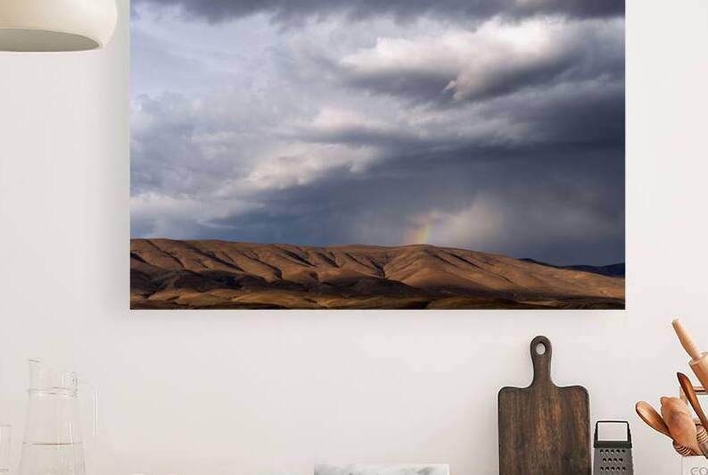 Rainbow with diagonal clouds over morning light on mountains by Lisa von Biela