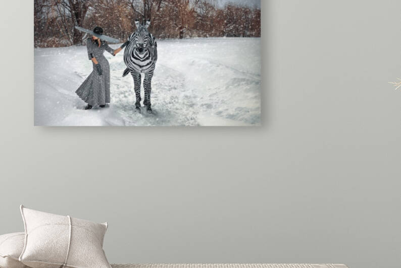 Beautiful young blonde woman wearing a long houndstooth pattern dress a large black hat and gloves standing in a snow storm with a zebra beside her in front of trees by Artmood Visualz