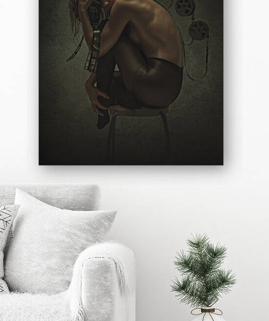 Young blonde woman with wet hair wearing black nylons and curled up on a stool fed by film reels upon her back and around her head in a dark atmosphere by Artmood Visualz