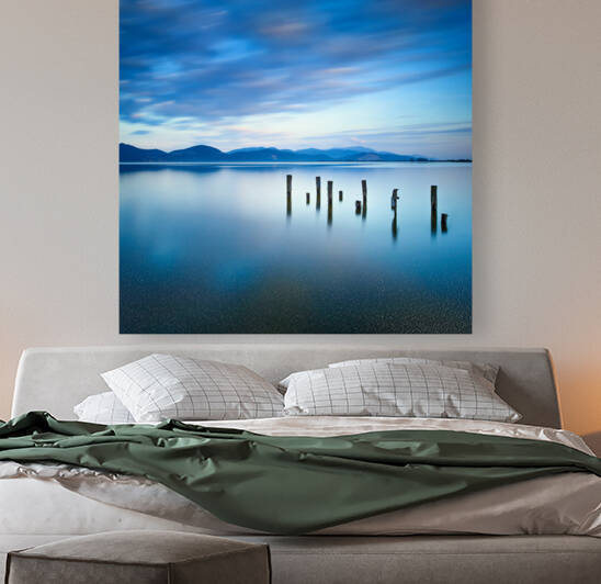 Wooden pier remains on a blue lake. Italy by Stefano Orazzini