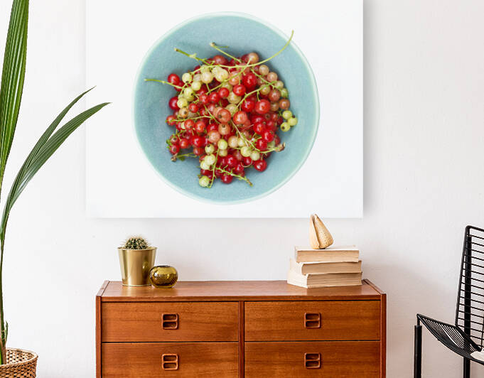 Red and Green Current in Blue Bowl on White by Iris H Richardson