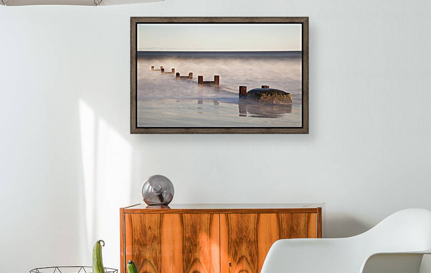 Wooden Posts And Boulders Immersed In Water At The Coast; Northumberland, England by PacificStock