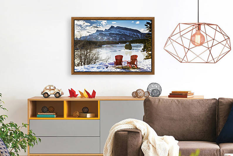 Two red chairs on snow covered ridge overlooking frozen lake with snow covered mountain in the background with blue sky and clouds; Banff, Alberta, Canada by PacificStock