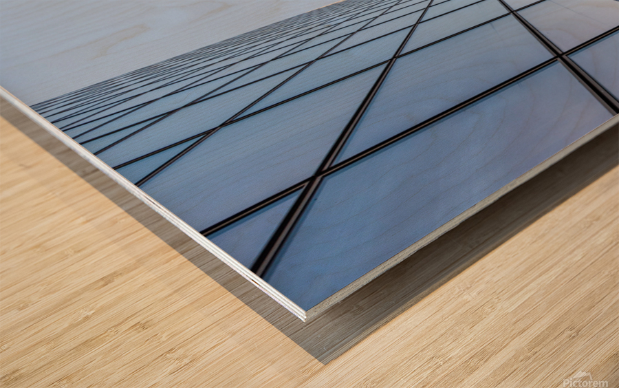 Blue curved glass skyscraper facade against sky Wood print