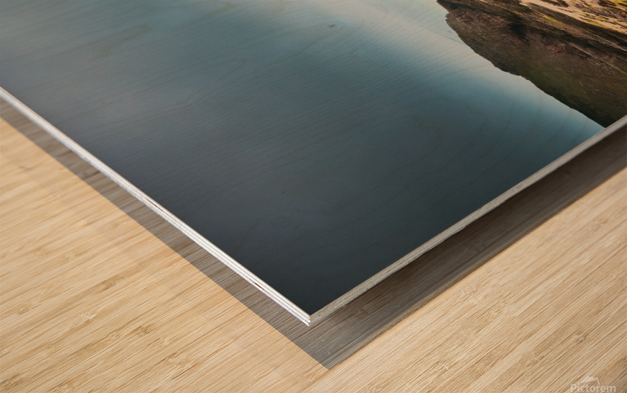 Beach with rocks and cloudy dark sky Wood print